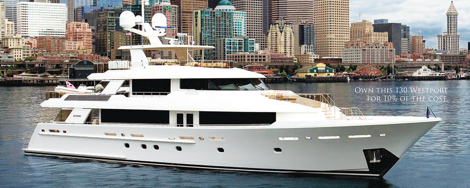 A large white boat in the water near some buildings.